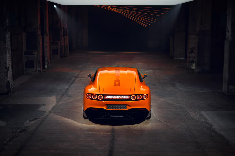 High-angle rear view of the Mercedes-AMG GT XX Concept emphasizing its sculpted fastback design, active rear diffuser, and animated LED tail panel.